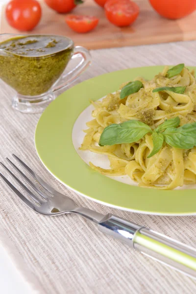 Massa deliciosa com pesto no prato na mesa close-up — Fotografia de Stock