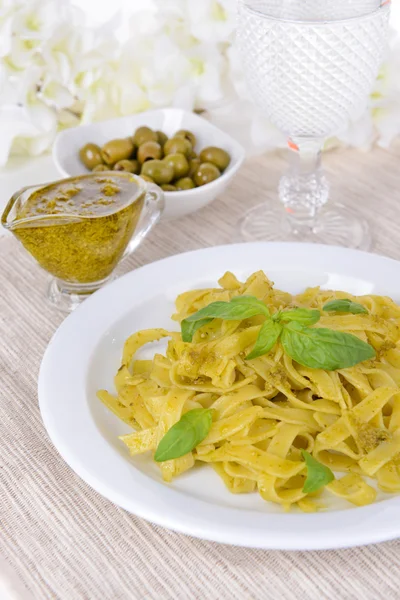 Massa deliciosa com pesto no prato na mesa close-up — Fotografia de Stock