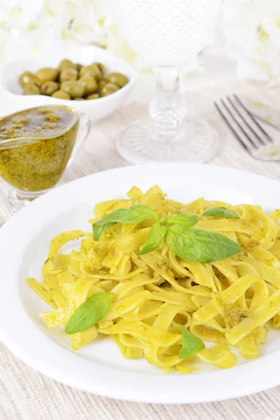 Massa deliciosa com pesto no prato na mesa close-up — Fotografia de Stock