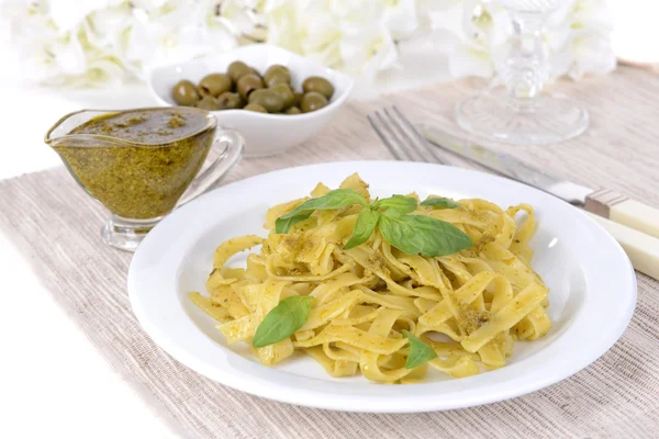 Massa deliciosa com pesto no prato na mesa close-up — Fotografia de Stock