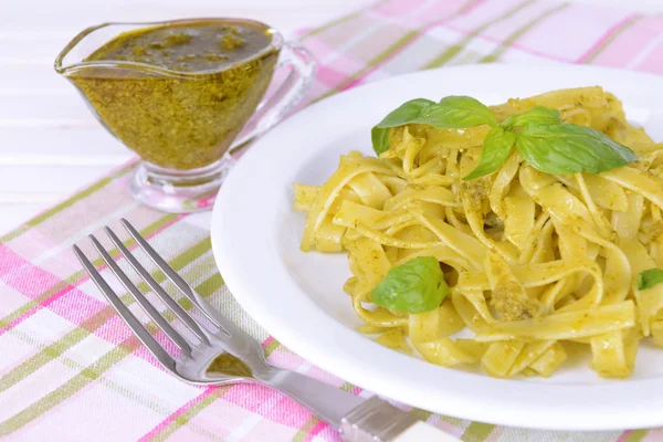 Massa deliciosa com pesto no prato na mesa close-up — Fotografia de Stock