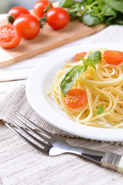 Pyszne spaghetti z pomidorami na tabliczce na stół szczegół — Zdjęcie stockowe