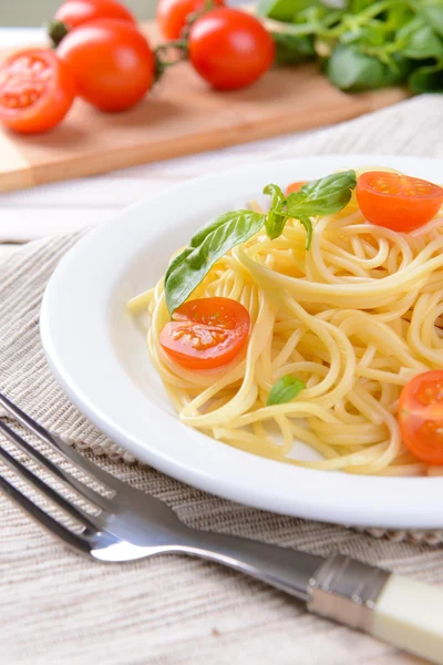 Delicious spaghetti with tomatoes on plate on table close-up — Stock Photo, Image