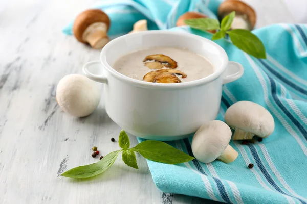 Mushroom soup in white pot, on napkin,  on wooden background — Stock Photo, Image