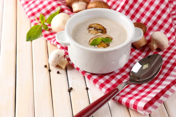 Champignonsoep in witte pot, op servet, op houten achtergrond — Stockfoto