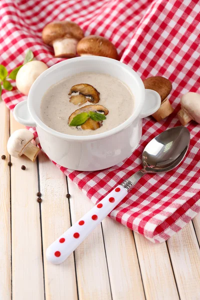 Mushroom soup in white pot, on napkin, on wooden background — Stock Photo, Image