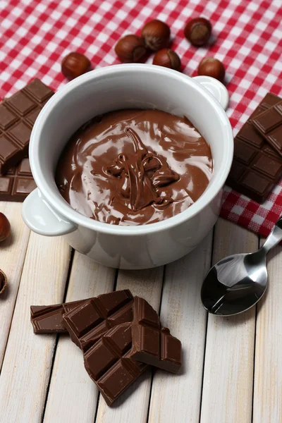 Söt choklad hasselnöt sprida med hela nötter och mynta på trä bakgrund — Stockfoto