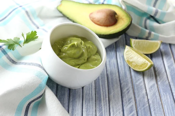 Guacamole fresco na tigela na mesa de madeira — Fotografia de Stock