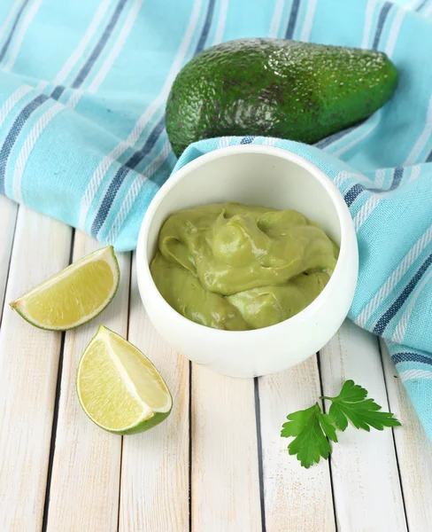 Fresh guacamole in bowl on wooden table — Stock Photo, Image