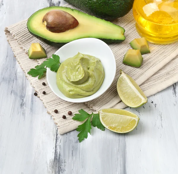 Fresh guacamole in bowl on wooden table — Stock Photo, Image