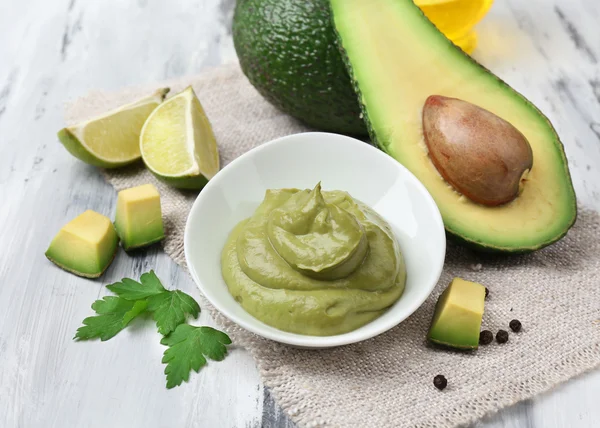Färsk guacamole i skål på träbord — Stockfoto