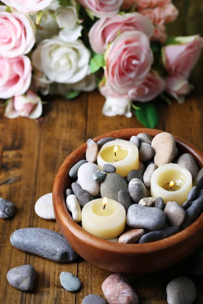 Composição com pedras de spa, velas e flores sobre fundo brilhante — Fotografia de Stock