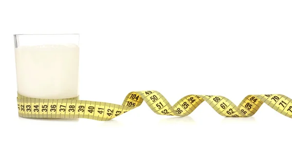 Glass of milk with measuring tape isolated on white — Stock Photo, Image