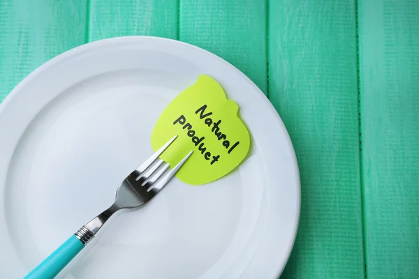 Note paper with message  attached to fork, on plate, on color wooden background — Stock Photo, Image