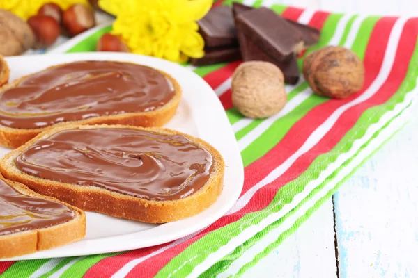 Kenyér édes csokoládé mogyoró elterjedt tányéron az asztalon — Stock Fotó