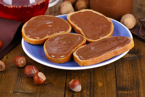 Bread with sweet chocolate hazelnut spread on plate on table — Stock Photo, Image