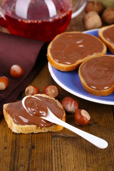 Pan con avellana de chocolate dulce extendido en el plato en la mesa —  Fotos de Stock