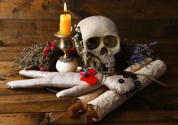 Conceptual photo of love magic. Composition with skull, voodoo doll, dried herbs and candle on  dark wooden background — Stock Photo, Image