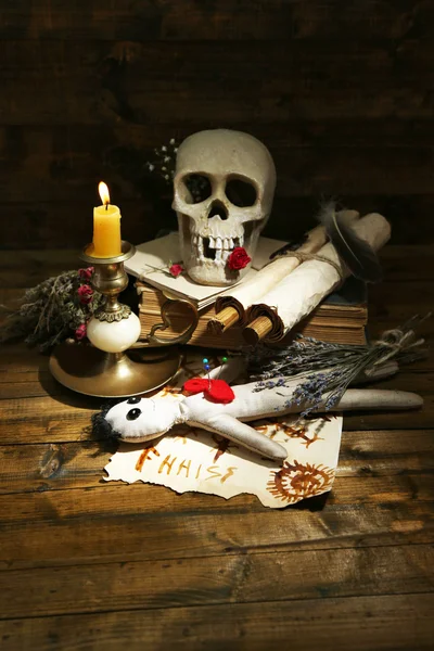 Conceptual photo of love magic. Composition with skull, voodoo doll, dried herbs and candle on  dark wooden background — Stock Photo, Image