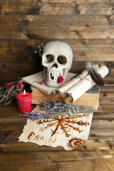 Foto conceptual de la magia del amor. Composición con cráneo, muñeca vudú, hierbas secas y vela sobre fondo de madera oscura —  Fotos de Stock