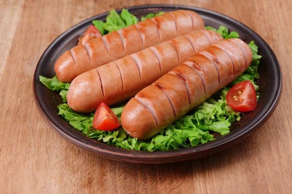 Жареная колбаса на тарелке на столе крупным планом — стоковое фото