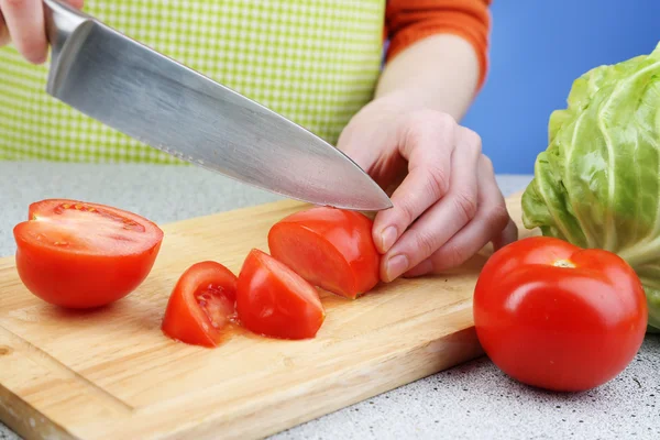 Frauenhände schneiden Tomaten auf Holzbrett, Nahaufnahme — Stockfoto