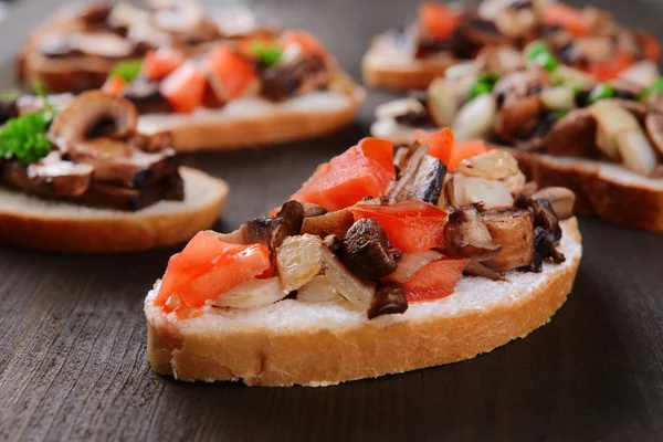Delicious bruschetta with mushrooms on table close-up — Stock Photo, Image