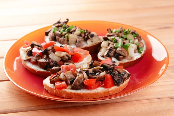 Delicioso bruschetta com cogumelos na placa na mesa close-up — Fotografia de Stock