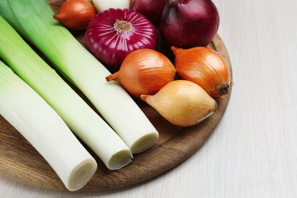 Different raw onion on wooden background — Stock Photo, Image