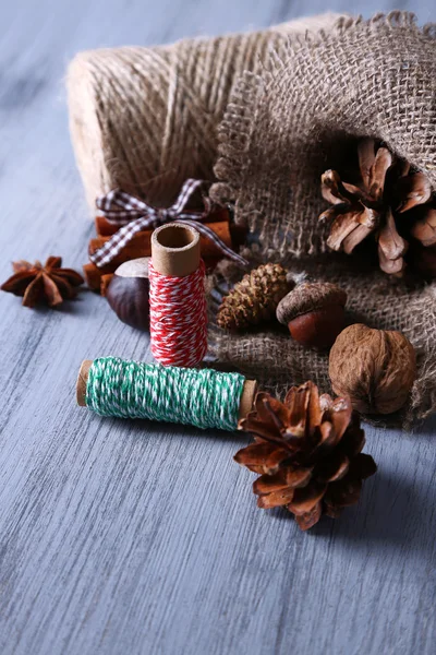 Composition with natural bump, thread, cinnamon sticks on wooden background — Stock Photo, Image