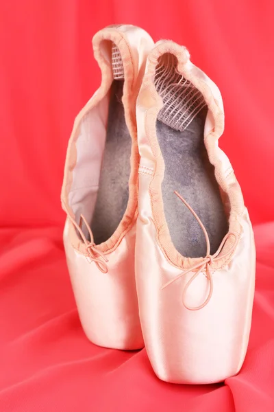 Sapatos de ponteiro de balé no fundo tecido vermelho — Fotografia de Stock