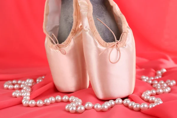 Zapatillas de punto de ballet sobre fondo de tela roja — Foto de Stock