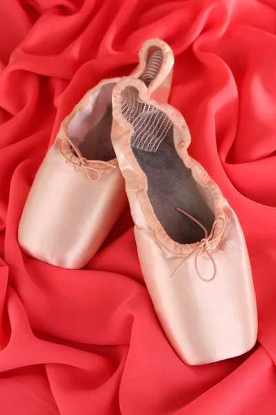 Zapatillas de punto de ballet sobre fondo de tela roja — Foto de Stock