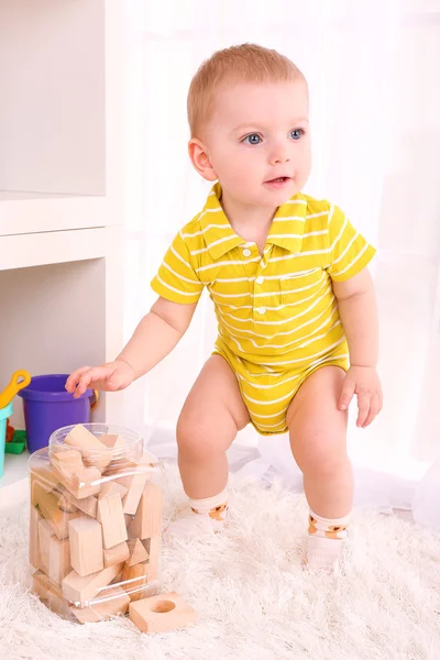 Söt liten pojke med trä leksak blockerar i rum — Stockfoto