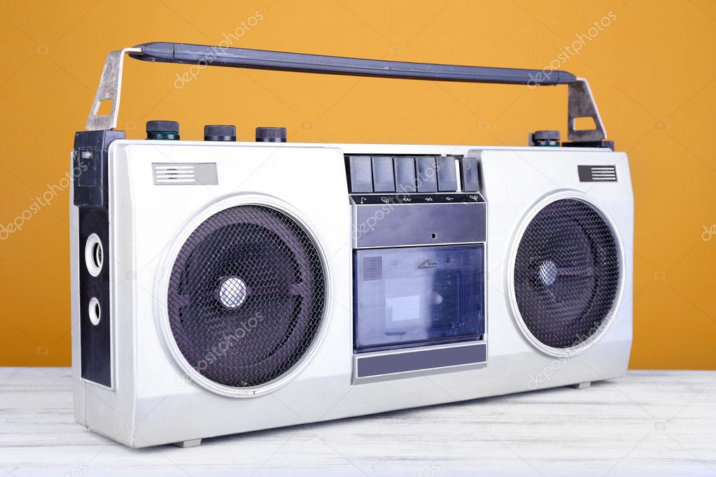 Retro cassette stereo recorder on table on yellow background