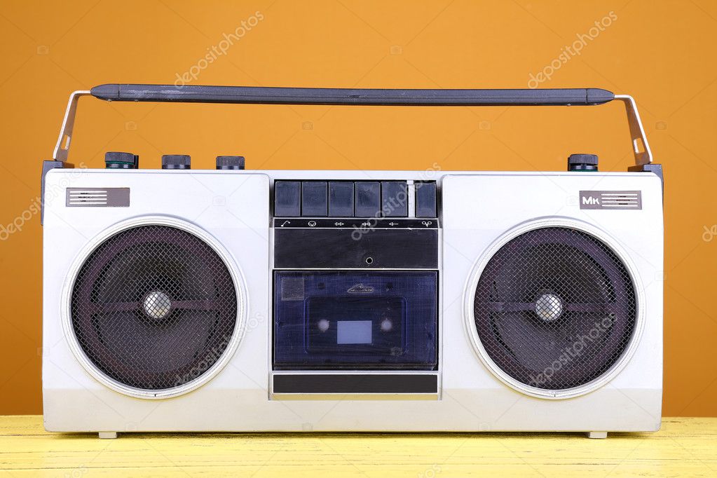 Retro cassette stereo recorder on table on yellow background