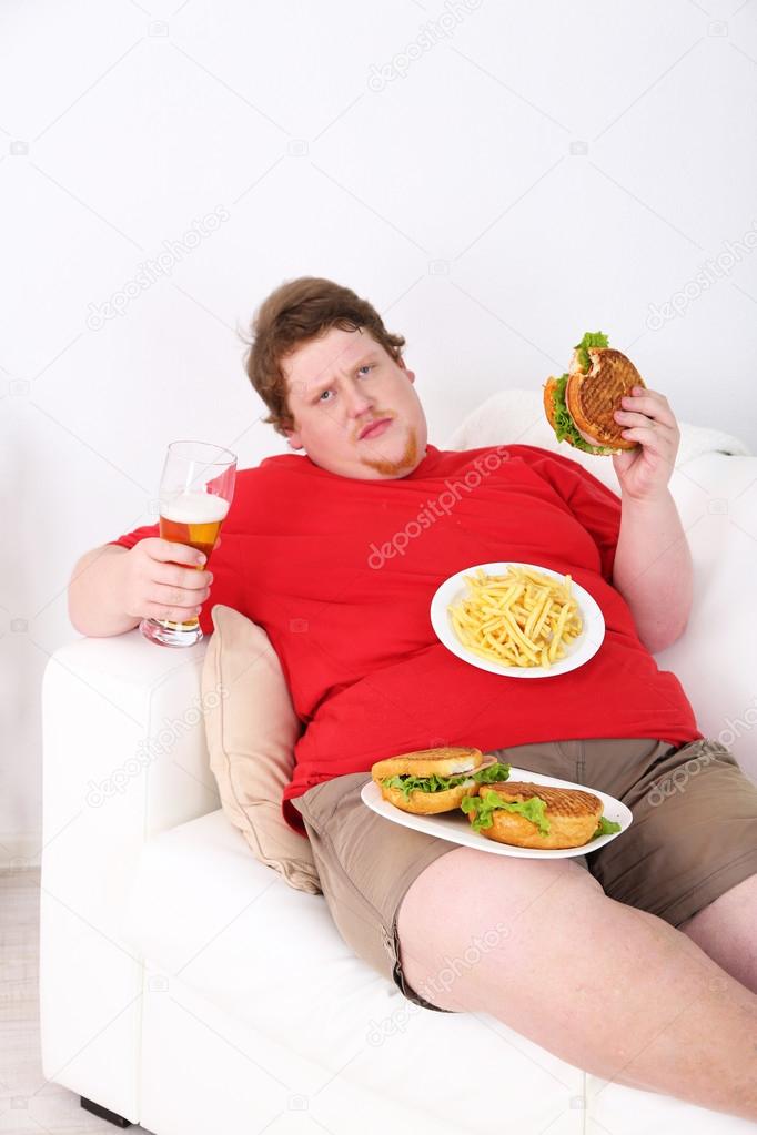 Fat man eating tasty sandwich