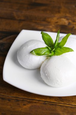 lezzetli mozzarella peyniri Fesleğenli ahşap zemin üzerinde plaka üzerinde