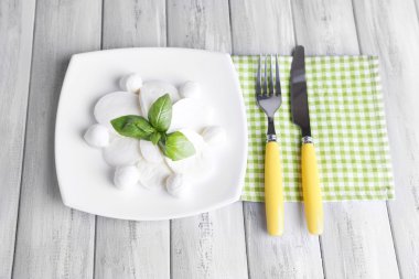 lezzetli mozzarella peyniri Fesleğenli ahşap zemin üzerinde plaka üzerinde