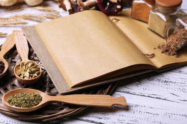 farklı baharatlar ve tahta masada yemek kitabı kapat