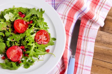 roka, domates ve susam ahşap zemin üzerinde plaka üzerinde yapılmış yeşil salata