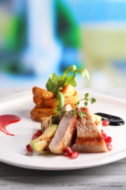 kızarmış patates ve kemik iliği parçaları ve nar taneleri parlak zemin üzerine ahşap masa üzerinde plaka üzerinde ızgara et