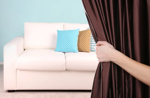 Hand opening curtain on room background — Stock Photo, Image