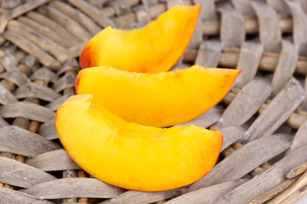 Ripe peaches on wicker mat close-u — Stock Photo, Image