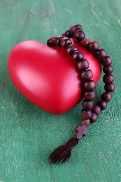 Hjärta med radband pärlor på trä bakgrund — Stockfoto