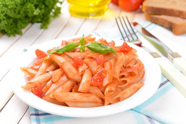 Pasta med tomatsås på tallriken på bordet närbild — Stockfoto