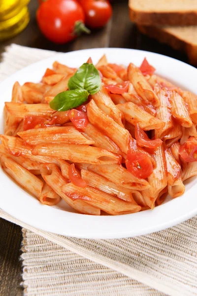 Pasta met tomatensaus op plaat op tabel close-up — Stockfoto