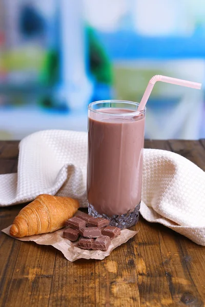 Leche de chocolate en vaso, sobre mesa de madera, sobre fondo brillante — Foto de Stock