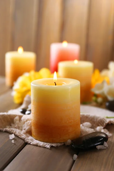 Hermosas velas con flores sobre fondo de madera — Foto de Stock