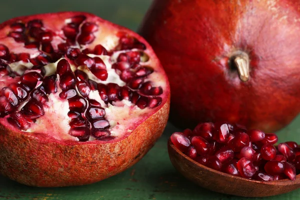 Reife Granatäpfel auf farbigem Holzhintergrund — Stockfoto